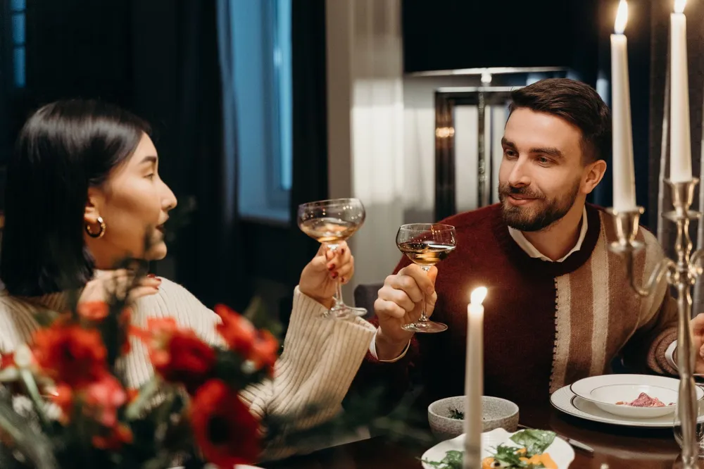 Pareja brindando en una cena elegante a la luz de las velas, seducir a un Capricornio