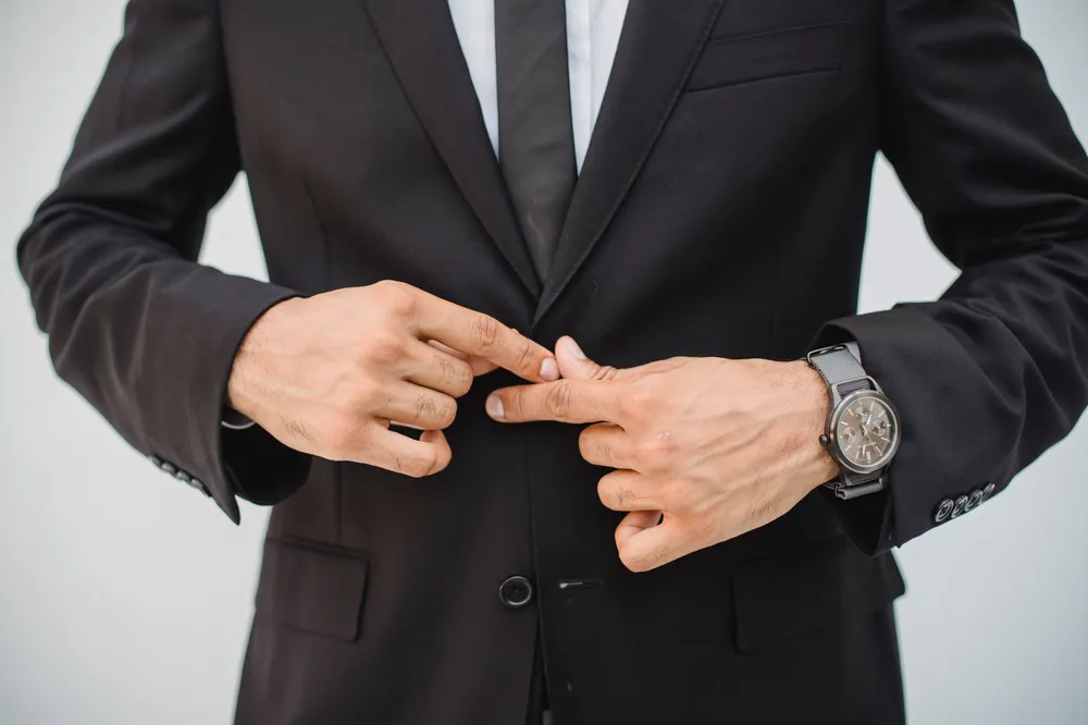 Hombre de traje ajustándose el reloj, el tiempo del hombre Capricornio