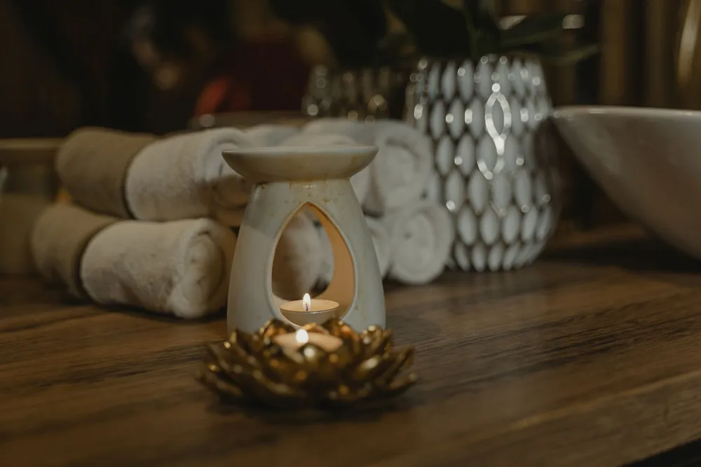 Velas y toallas preparadas para una sesión de masaje nuru en casa
