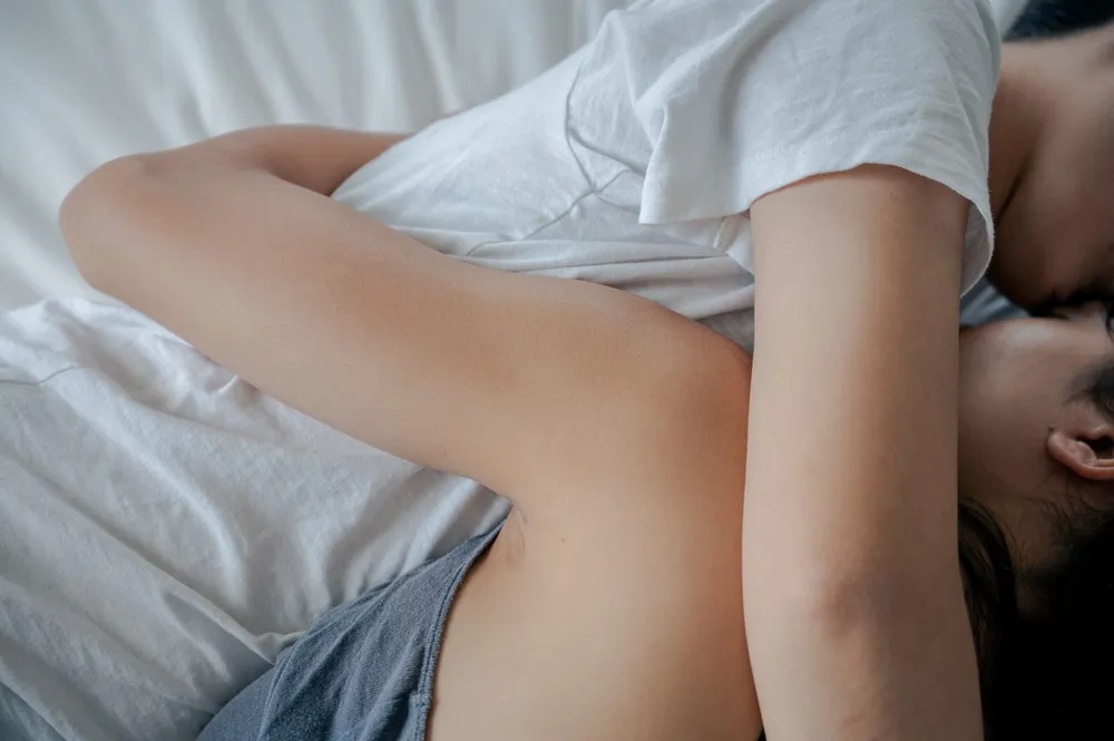 Pareja abrazada en la cama con ternura, la entrega de la mujer Piscis