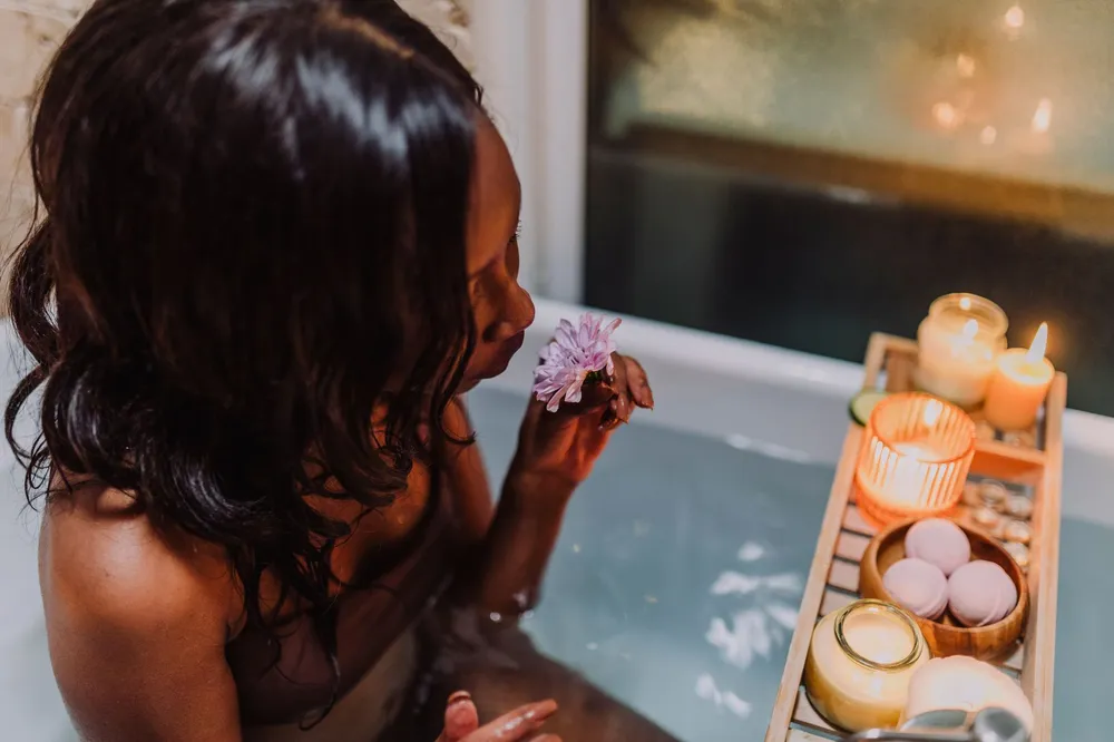 Mujer relajándose en un baño con velas, el agua, elemento de Piscis