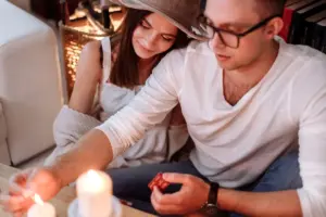 Pareja encendiendo velas en un ambiente íntimo — el hombre Piscis romántico