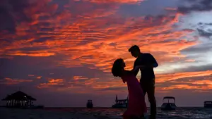 Pareja en silueta en la playa al atardecer en verano