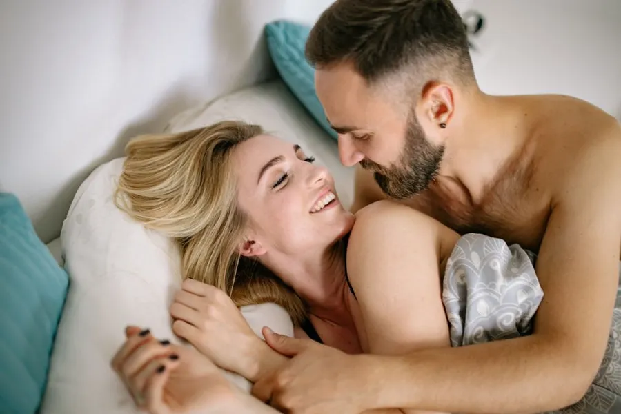 Pareja cómplice en la cama: la talla correcta del preservativo mejora la experiencia