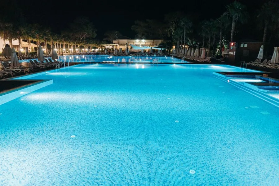 Piscina iluminada de noche en verano
